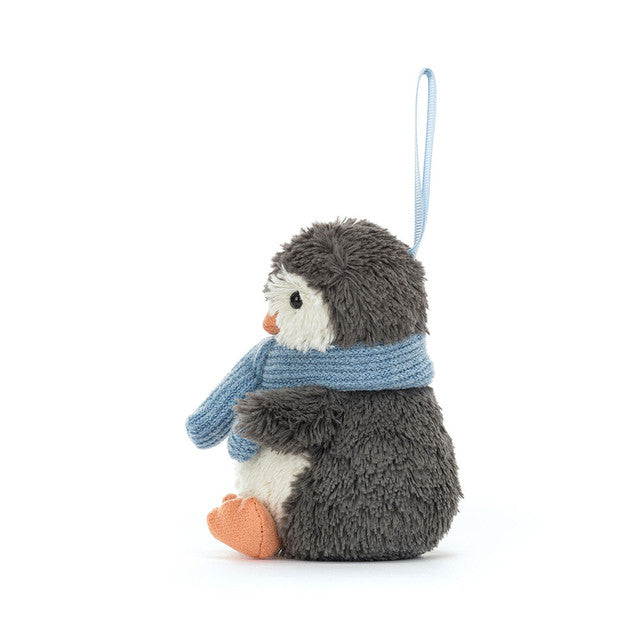 A plush gray and white penguin ornament with a blue scarf and orange feet.