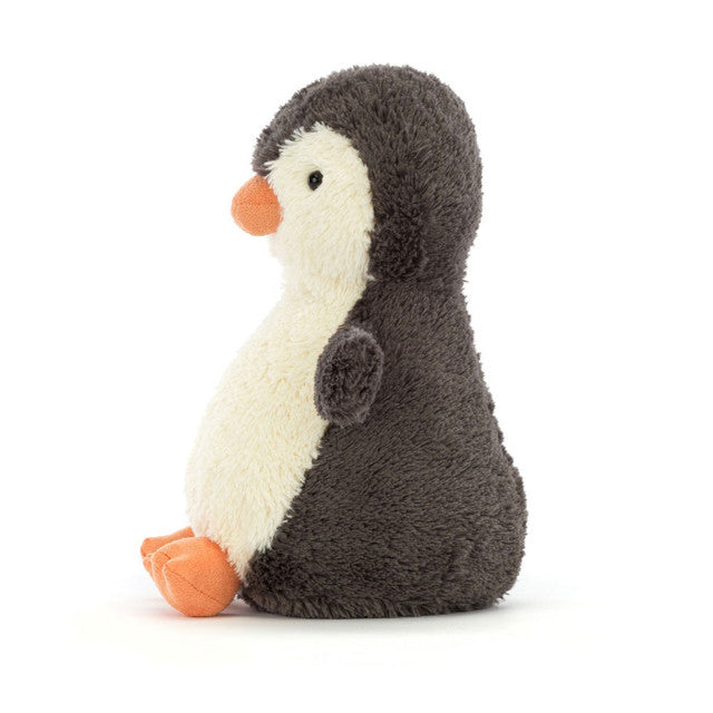 A small, plush penguin toy with dark gray and cream fur, an orange beak, and feet.