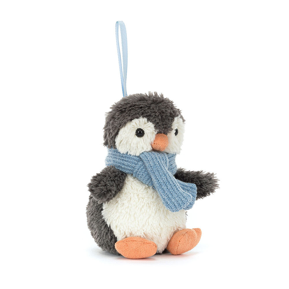 A fluffy gray and white penguin ornament with an orange beak and feet, wearing a blue scarf.