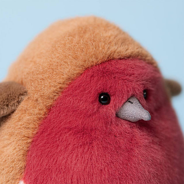A plush toy robin with a red breast and brown back, featuring black eyes and a gray beak.