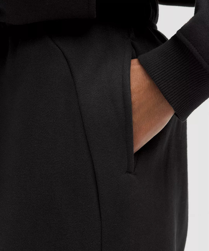 Black scuba mid-rise oversized joggers with a hand in the pocket.