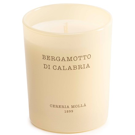 An ivory mini candle in a glass jar with "Bergamotto Di Calabria" printed on it.