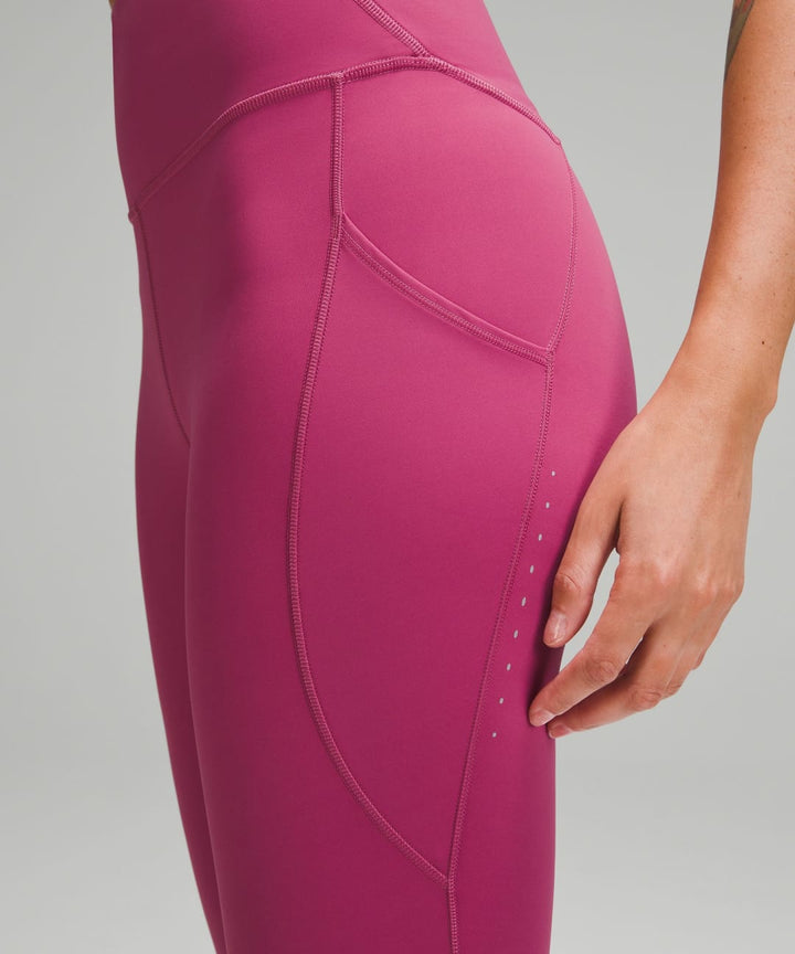 Close-up of mauve high-rise leggings with pockets and reflective dots.