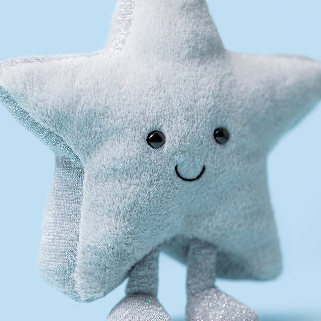 A plush silver star toy with a smiling face and sparkly legs.