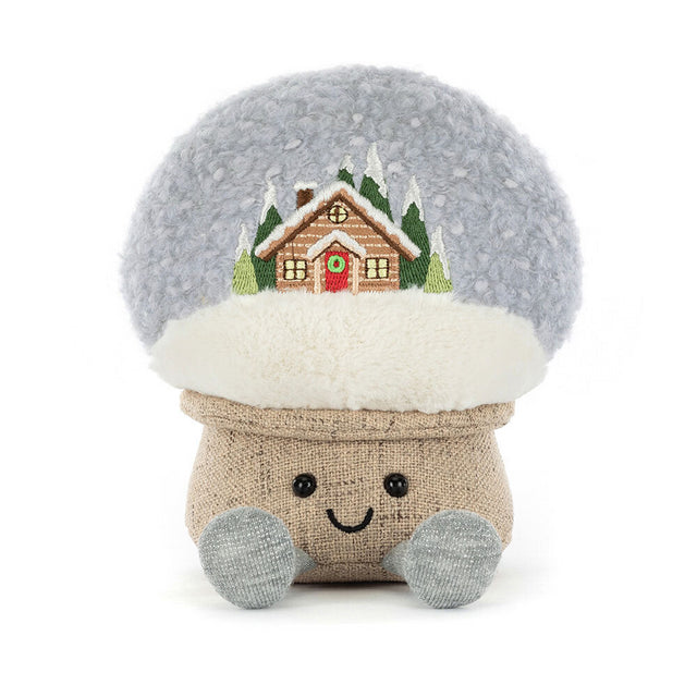 A plush snow globe with an embroidered cabin scene and a smiling face.
