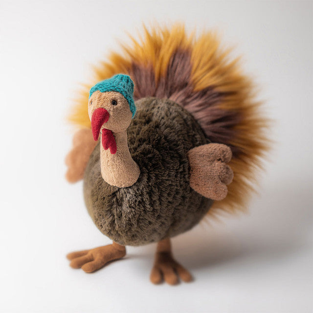 A plush toy turkey wearing a teal knitted hat.