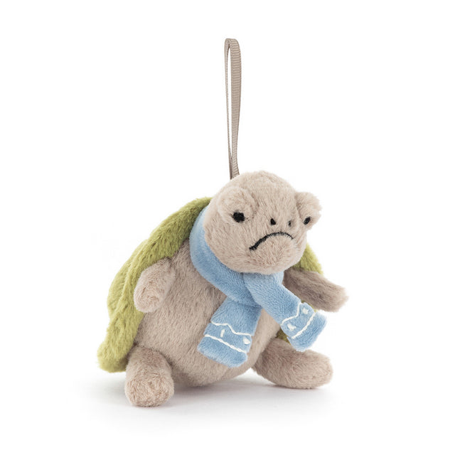 A plush turtle ornament with a grumpy expression and a blue scarf.