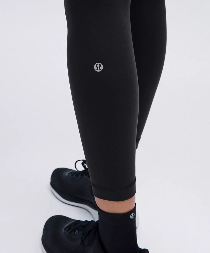 Black leggings with a silver logo on the thigh and ankle.