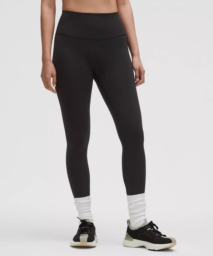 Black high-rise leggings with white socks and sneakers.