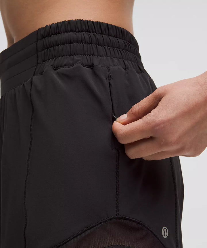 Black Hotty Hot High-Rise Lined Short 4" with a hand opening a zippered pocket.